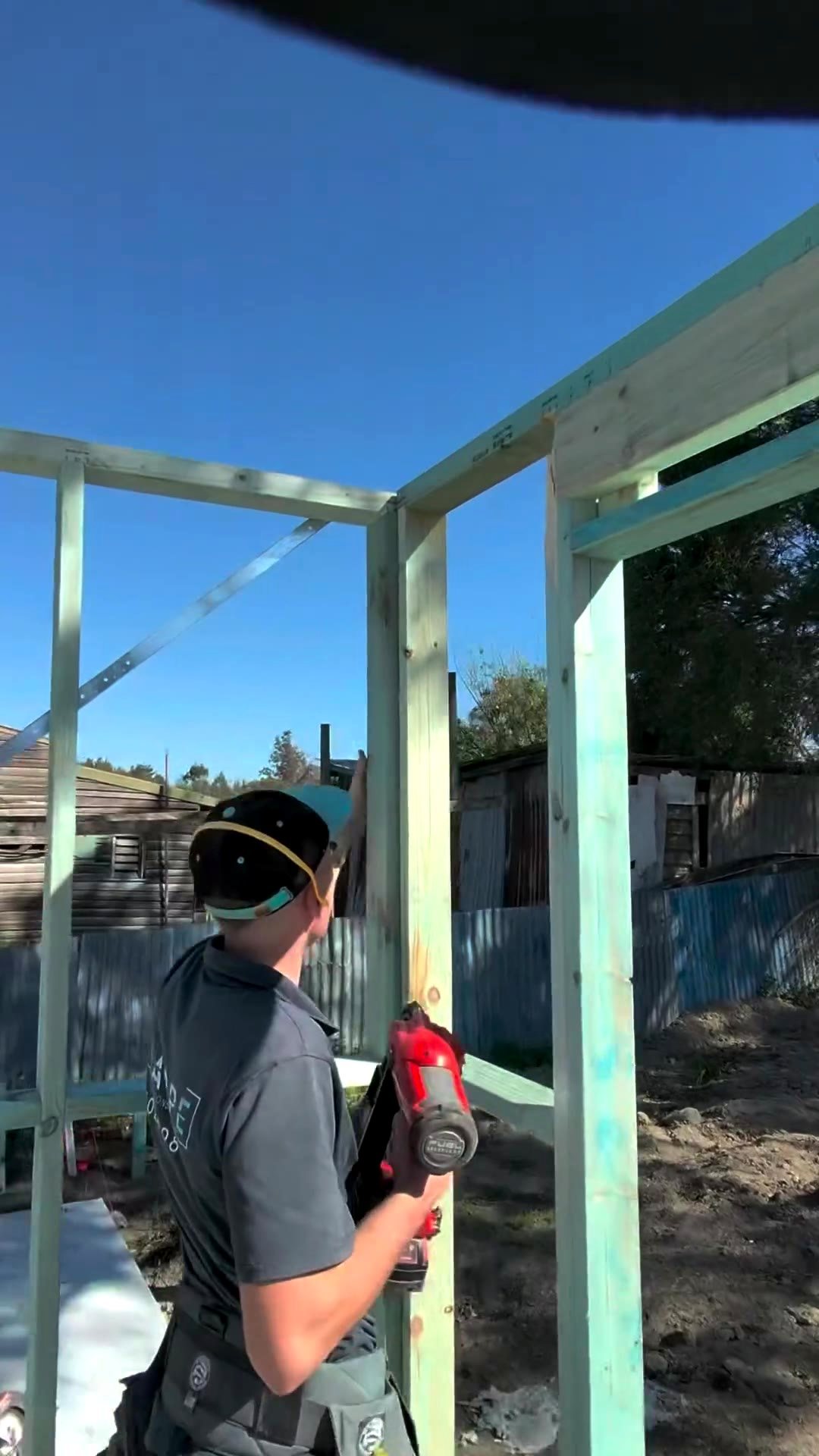 Liam framing a wall with a nail gun